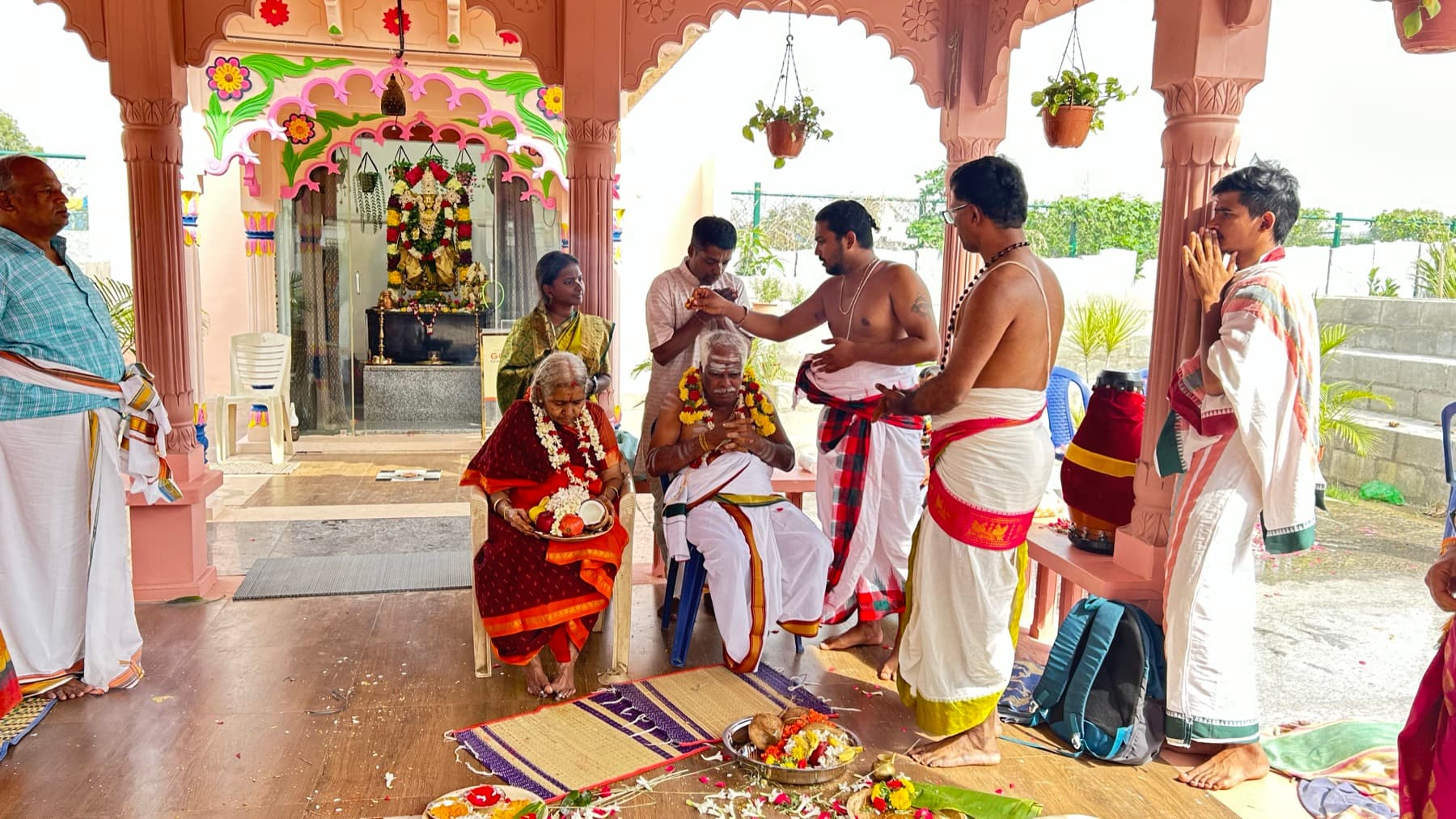A ceremony being performed for an elderly couple at a temple shrine